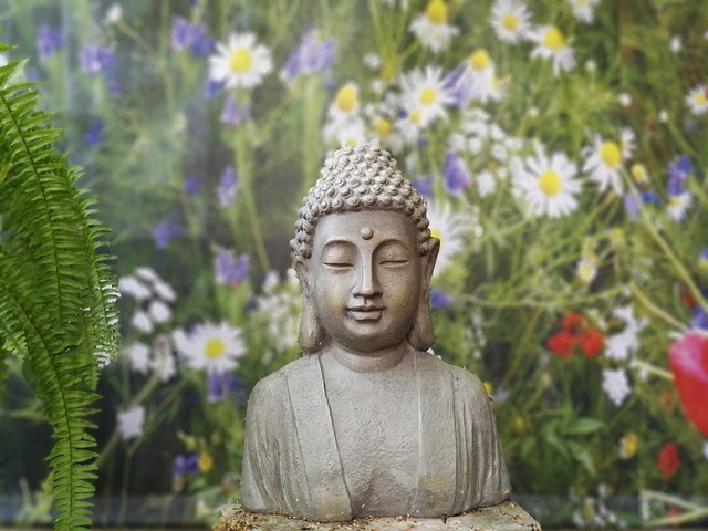 פסל של בודהה בשדה פרחים