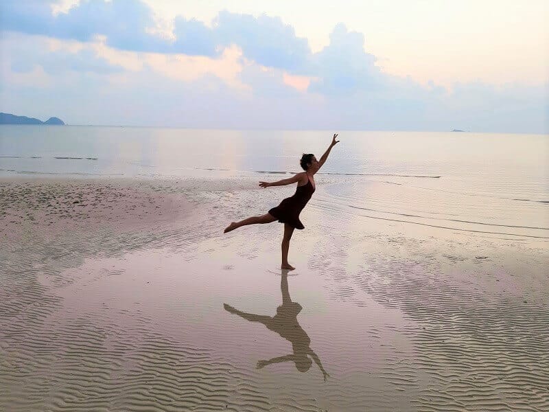מיכל פולת בתנוחת ריקוד על החוף בקופנגן שמייצגת מעבר בין העולם הישן לעולם החדש